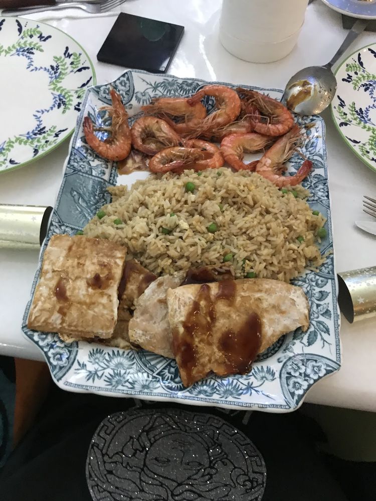 A blue-and-white platter of large shell-on cooked prawns with egg fried rice and glazed fish fillets
